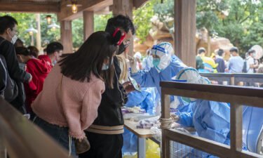 China's Covid-19 curbs are again hurting business. Medical workers here carry out Covid-19 testing on tourists at Shanghai Disney Resort on October 31