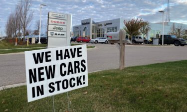A sign reading "We have new cars in stock!" is pictured here outside of a car dealership Ann Arbor
