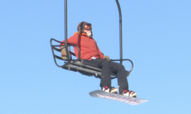 Snowboarder riding lift at Pebble Creek