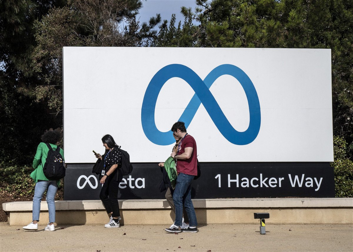 <i>Terry Schmitt/UPI/Shutterstock</i><br/>People walk by a sign on the Meta campus In Menlo Park
