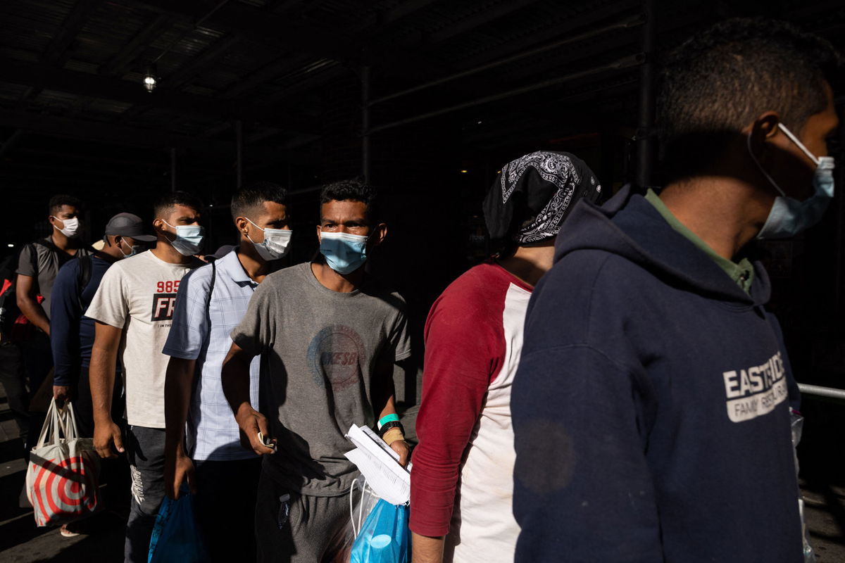 <i>Yuki Iwamura/AFP/Getty Images</i><br/>A group of migrants wait in line after arriving from Texas