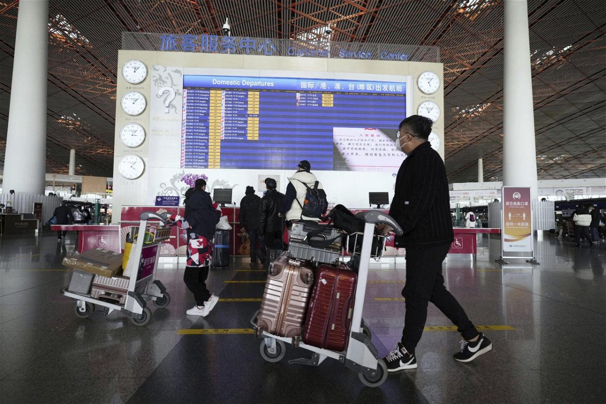 <i>KYDPL KYODO/AP</i><br/>People walk with suitcases through a departure lobby the Beijing airport on December 27.