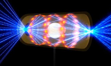 This illustration depicts a target pellet inside a hohlraum capsule with laser beams entering through openings on either end. The beams compress and heat the target to the necessary conditions for nuclear fusion to occur.