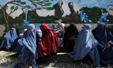 Afghan women wait to receive a food package being distributed by a Saudi Arabia humanitarian aid group at a distribution center in Kabul