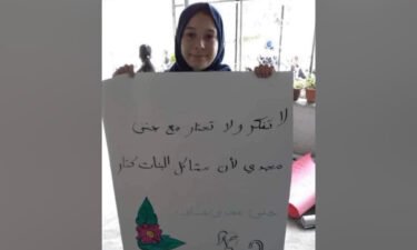 Jana Zakarneh raises a placard with verses she wrote during a school activity. Zakarneh was killed in an Israeli military raid on the occupied West Bank city of Jenin.