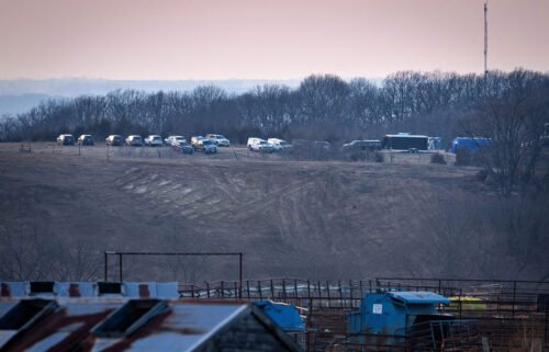 A line of vehicles parked near the rural Iowa site where authorities were searching for human remains said to have been buried there by a serial killer.
