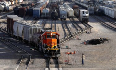 A BNSF rail terminal worker monitors the departure of a freight train