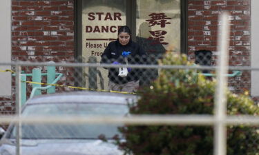 An investigator carries markers outside Star Dance Studio in Monterey Park