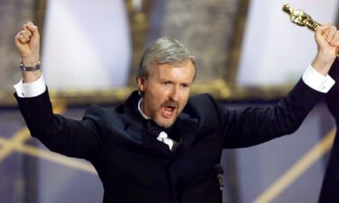 James Cameron holds up the Oscar he won for best director for the movie "Titanic" March 23