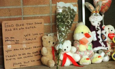 A hand-written sign is seen next to toys and flowers left by residents at Buell Elementary School in the days after Kayla's shooting.