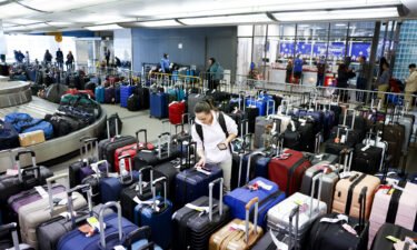 A traveler searches for a friend's suitcase in a baggage holding area for Southwest Airlines at Denver International Airport on December 28