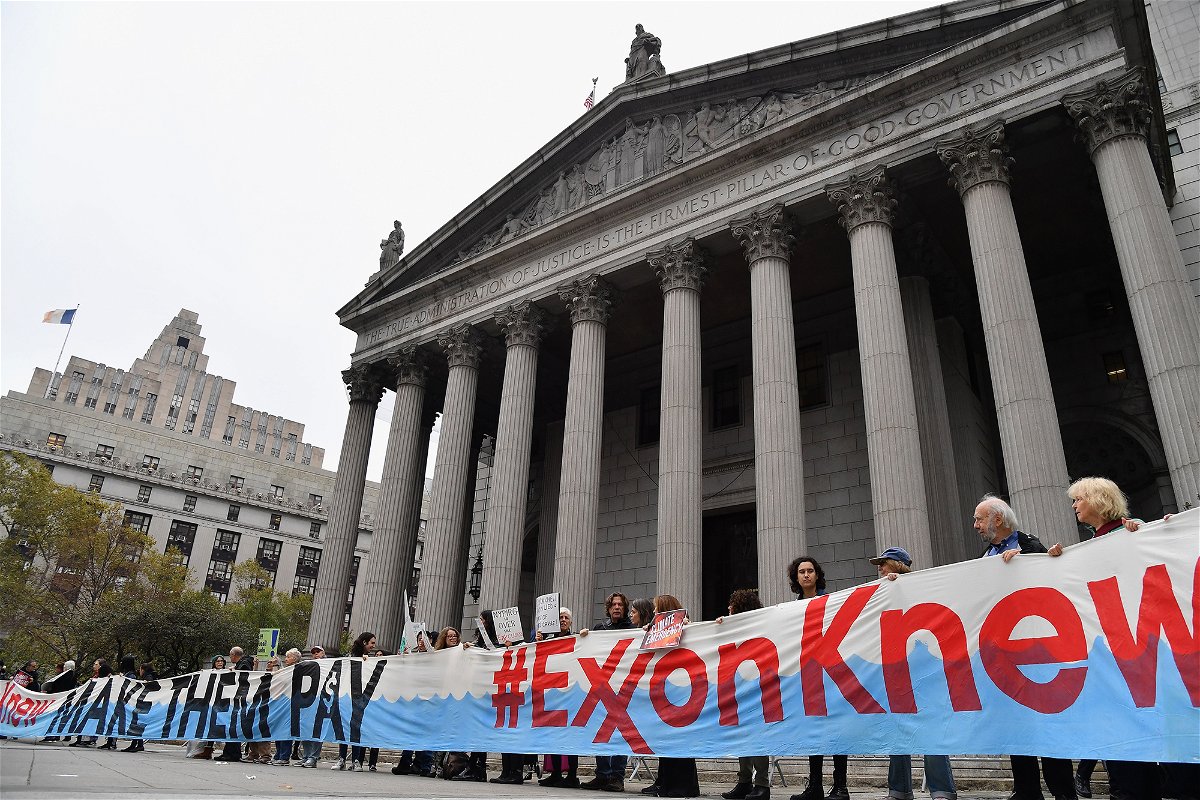 <i>Angela Weiss/AFP/Getty Images</i><br/>Climate activists on the first day of  ExxonMobil's trial outside the New York State Supreme Court building in October 2019. Exxon won the case