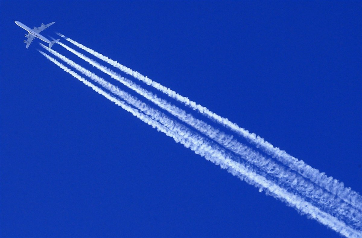 <i>ALEXANDER KLEIN/AFP/AFP via Getty Images</i><br/>A Qatar Airways Airbus A340 airplane leaves contrails in the sky.