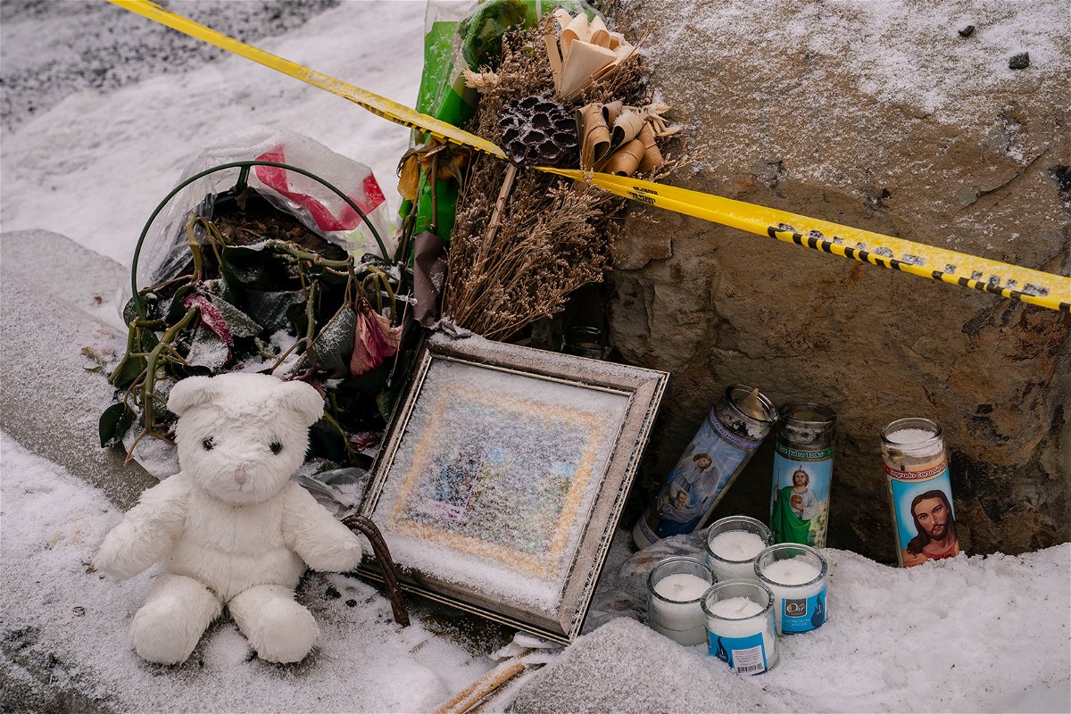 <i>David Ryder/Getty Images</i><br/>Mourners leave a makeshift memorial outside the scene of the killings on January 3.