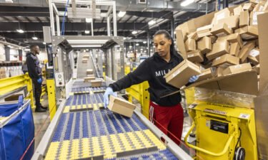 Online prices dropped in December. A United States Postal Service employee processes packages as they prepare for the busy holiday season on December 12