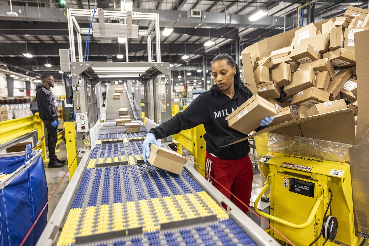 <i>Alejandra Villa Loarca/Newsday RM/Getty Images</i><br/>Online prices dropped in December. A United States Postal Service employee processes packages as they prepare for the busy holiday season on December 12