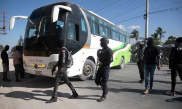 Masked officers force a driver to park his bus to be used as a barricade during a protest to denounce bad police governance