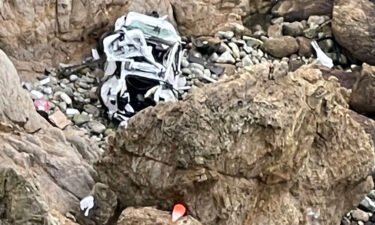 This image provided by the San Mateo County Sheriff's Office shows the Tesla on a rocky beach below the cliffs