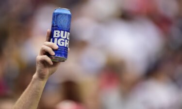 Bud Light and Budweiser are getting a makeover at this year's Super Bowl. A fan holds up a can of Bud Light during a game on October 6