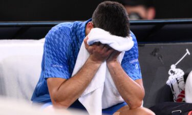 Djokovic cries into his towel after victory.