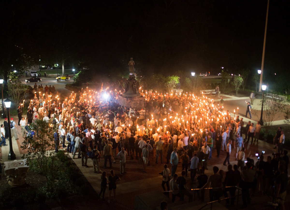 <i>NurPhoto/NurPhoto/NurPhoto via Getty Images</i><br/>White Supremacists encircle counter protestors at the base of a statue of Thomas Jefferson after marching through the University of Virginia campus with torches in Charlottesville