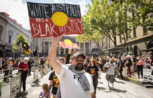 People march down Bourke street during the Invasion Day rally on January 26 in Melbourne