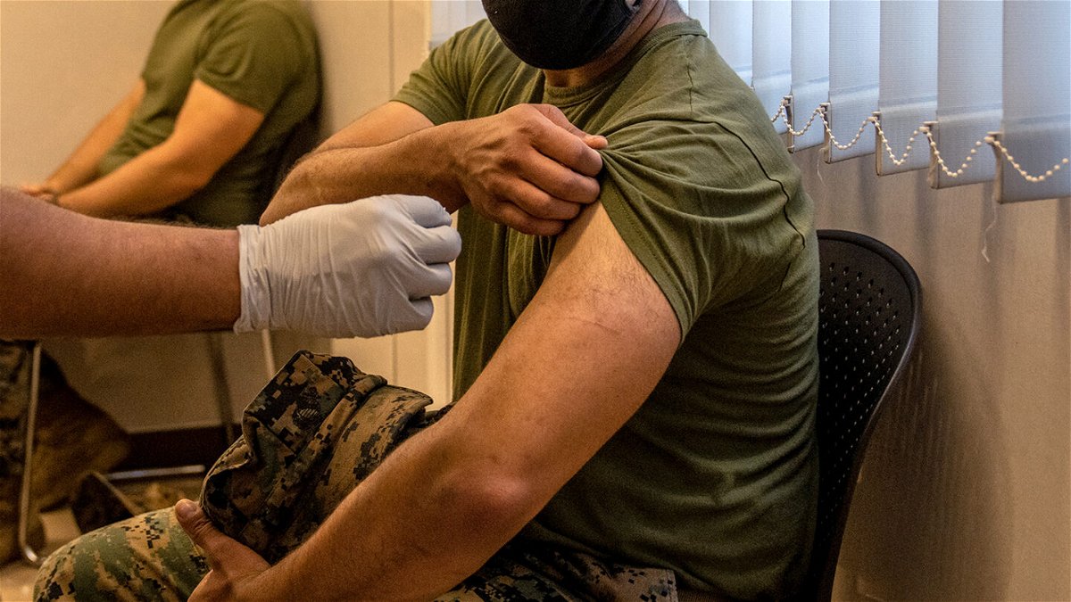 <i>Carl Court/Getty Images/FILE</i><br/>A US Marine prepares to receive the Moderna coronavirus vaccine at Camp Hansen in April of 2021