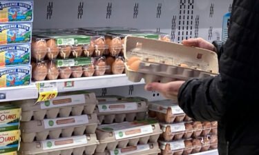 A shopper checks eggs before he purchases them at a grocery store in Glenview