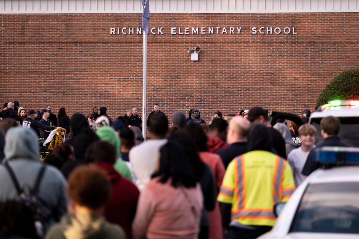 <i>Billy Schuerman/The Virginian-Pilot/AP</i><br/>Students and police gather outside of Richneck Elementary School after a shooting on January 6 in Newport News
