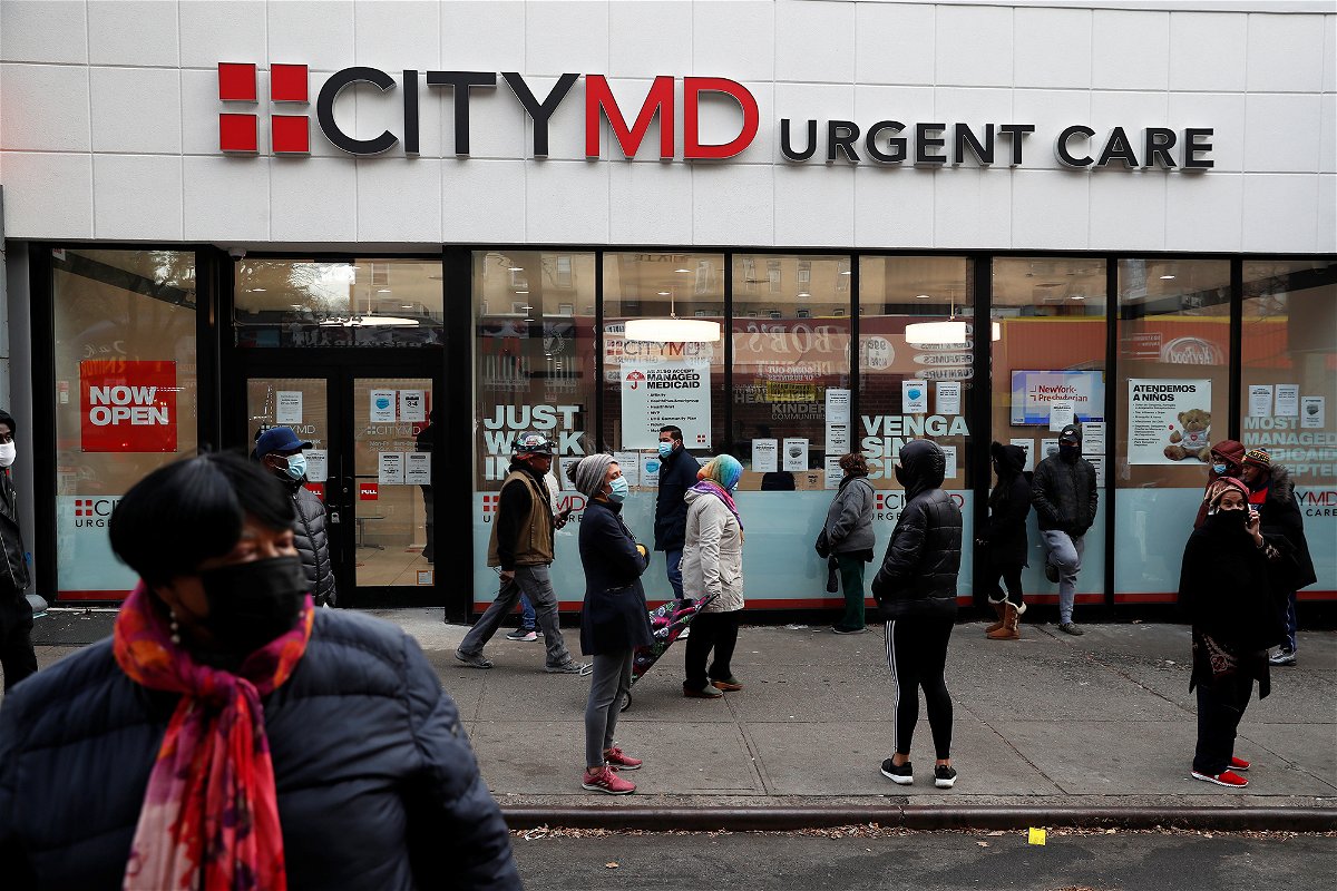 <i>Shannon Stapleton/Reuters</i><br/>People wearing protective face masks wait in line outside a CityMD Urgent Care in the Bronx borough of New York during the COVID-19 outbreak in November 2020.
