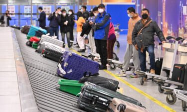 Travelers wait for their luggage at Shanghai Pudong International Airport as China lifts quarantine requirements for international arrivals on January 8