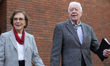 Former President Jimmy Carter walks with his wife Rosalynn after teaching Sunday School class in Plains