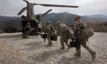 U.S. soldiers board an Army Chinook transport helicopter after it brought fresh soldiers and supplies to the Korengal Outpost on October 27