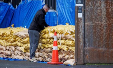 A man stacks up sandbags to protect a warehouse before the arrival of Cyclone Gabrielle in Auckland