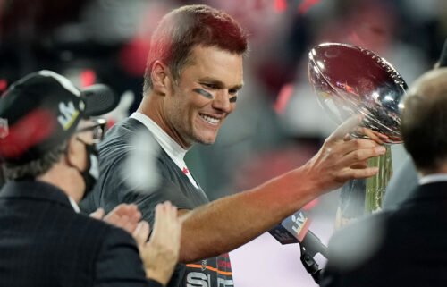 Brady looks at the Vince Lombardi trophy after defeating the Kansas City Chiefs in the Super Bowl on February 7