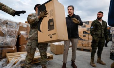 Blinken helps US military personnel load aid onto a vehicle at Incirlik Air Base in Turkey on February 19