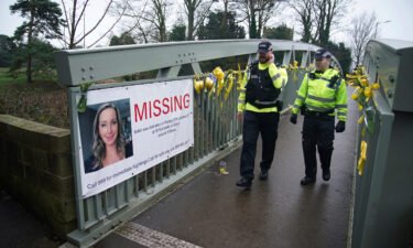 Police officers walk past a missing person appeal poster last week for Nicola Bulley on a bridge over the River Wyre in St. Michael's.