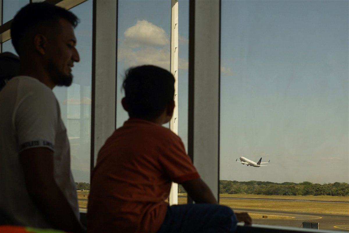 <i>Aphotografia/Getty Images</i><br/>A man and his son watch a United Airlines plane take off from Comalapa International Airport on February 18 in La Paz