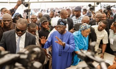 All Progressives Congress (APC) presidential candidate Bola Tinubu (C-L) and his wife Oluremi Tinubu (C-R) arrive to vote at a polling station in Lagos on February 25