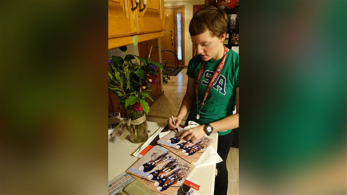 <i>Mark Catlin</i><br/>Kelly signing pictures from the Olympics for fans in the family home in Arden Hills