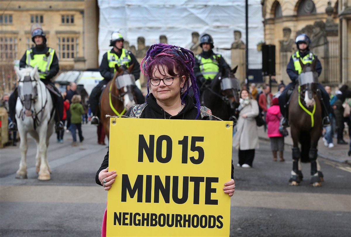 <i>Martin Pope/Getty Images</i><br/>A woman holds a placard at a protest against 15-minute cities in Oxford