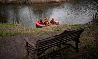 A search dog from Lancashire Police and a crew from Lancashire Fire and Rescue service search the River Wyre near the bench where Bulley's mobile phone was found