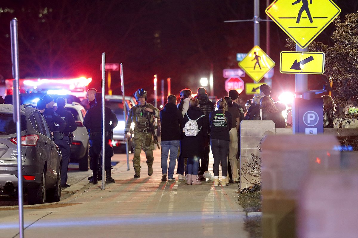 <i>Al Goldis/AP</i><br/>Students gather on the campus of Michigan State University after a shelter in place order was lifted early Tuesday.