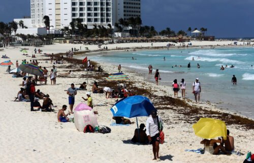 Tourists enjoy the beach despite the sargassum algae buildup in Cancun