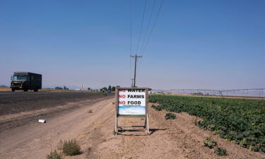 Traffic passes a sign reading "No Water