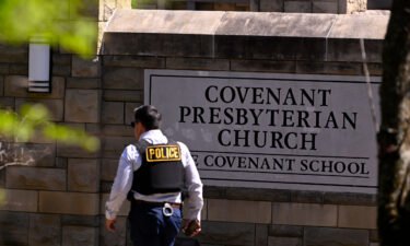 A police officer walks by an entrance to The Covenant School after a shooting in Nashville on March 27.