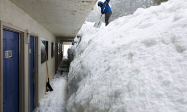 Cristian Nunez shovels a snowbank at a motel on March 11 in Mammoth Lakes