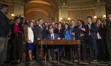 Gov. Gavin Newsom signs a bill aimed at addressing gas price gouging while surrounded by legislators and state officials in the Capitol rotunda on March 28 in Sacramento