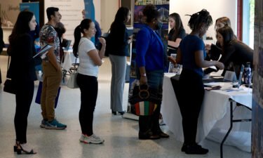 Job seekers stand in line at the Hyatt booth setup at the Mega South Florida Job Fair held in the FLA Live arena on February 23