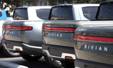 Rivian electric pickup trucks sit in a parking lot at a Rivian service center on May 09